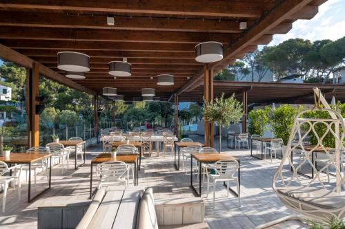 a restaurant with tables and chairs on a patio at ARTIEM Audax - Adults Only in Cala Galdana