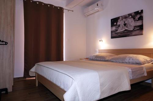 a bedroom with a bed and a large window at Apartments Nevenka i Josko in Tučepi