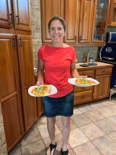 a woman standing in a kitchen holding two plates of food at Rock Pointe Ranch in Floral City