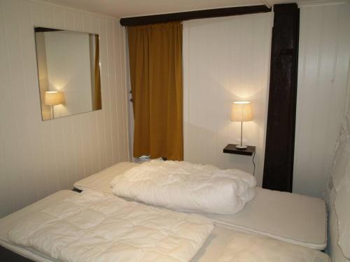 two beds in a small room with a mirror at Siloen - cosy apartment in Herand in Herand