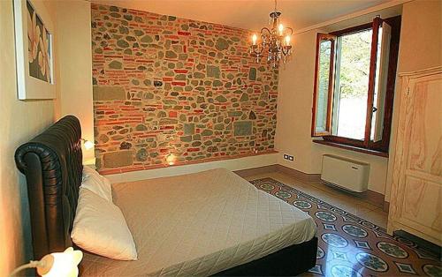 a bedroom with a bed and a stone wall at Agriturismo Il Casolare in Poppi