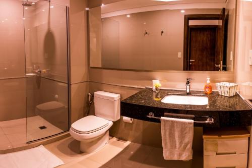 a bathroom with a toilet and a sink and a shower at Realty PY Villa Morra in Asuncion