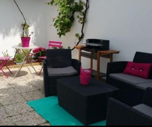 een woonkamer met een bank, stoelen en een tafel bij Maison carnac plage in Carnac