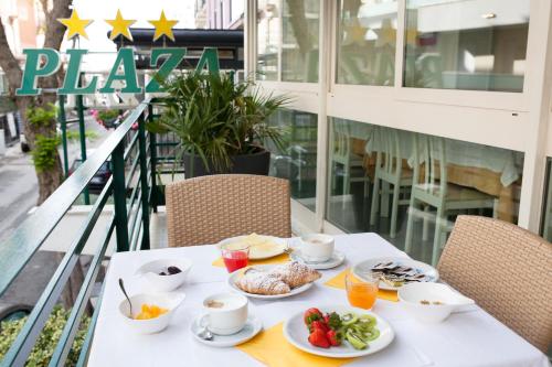 a table with food on it on a balcony at Hotel Plaza in Rimini