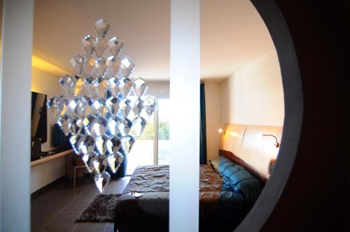 a room with a bed and a chandelier at Logis Hôtel La Fauceille in Perpignan