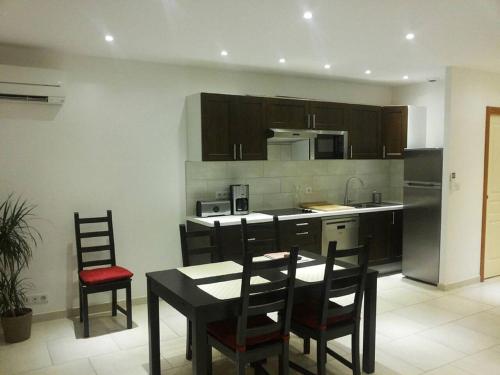 een keuken met een tafel en stoelen en een keuken met een fornuis bij PIETROSELLA Plage du RUPIONE in Pietrosella