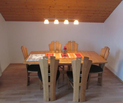uma mesa de jantar com cadeiras e uma mesa de madeira em Ferienwohnung Steible em Isny im Allgäu
