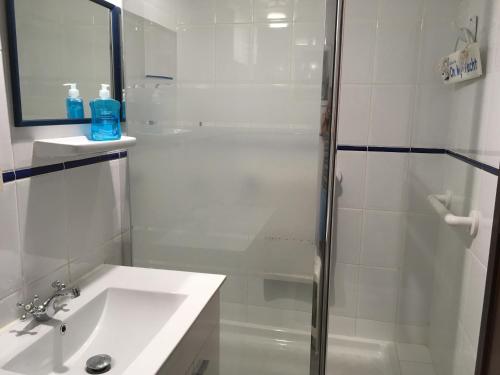 a white bathroom with a shower and a sink at Admirals Suite, Gibraltar in Gibraltar