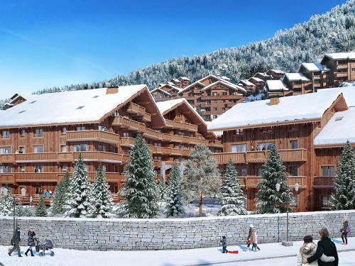 people walking in the snow in front of a lodge at Residence l Hevana - maeva Home in Méribel