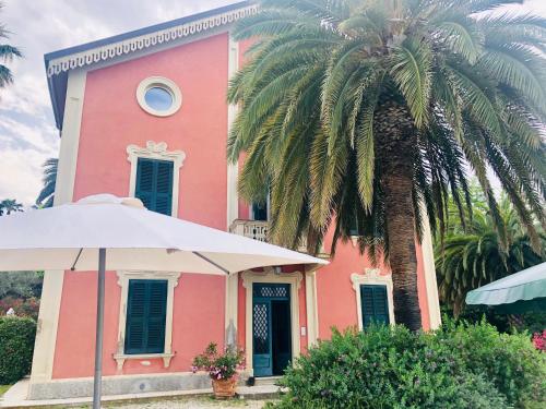 una casa rosa con una palmera delante de ella en Villachiara, en Silvi Marina