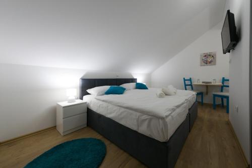 a bedroom with a large bed with blue pillows at House Smolčić in Otočac