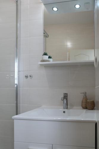 a white bathroom with a sink and a shower at House Smolčić in Otočac