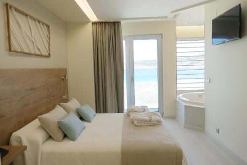 a bedroom with a bed with a view of the ocean at Hotel Boutique O Náutico Laxe in Laxe