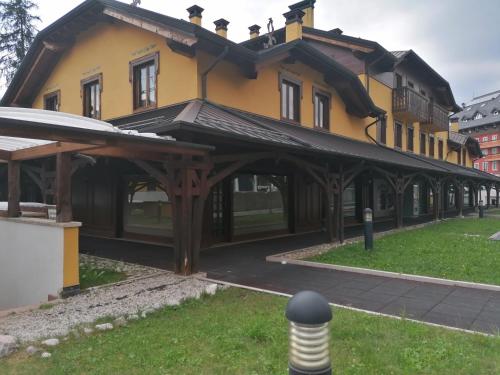 a large yellow building with a roof at Asiago Sporting Lodge in Asiago