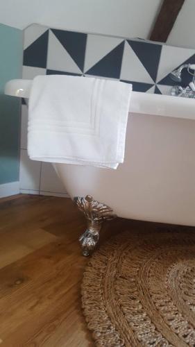 a white towel sitting on top of a bath tub at Au Jeu de Paume in Épernay