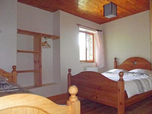 a bedroom with two wooden beds and a window at L'Asphodèle in Venterol