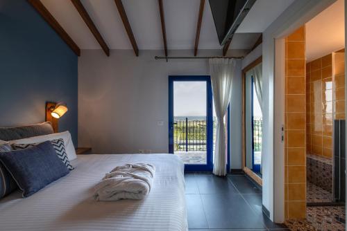 een slaapkamer met een bed en een groot raam bij Yama Wine Spa and Suites in Zikhron Ya‘aqov