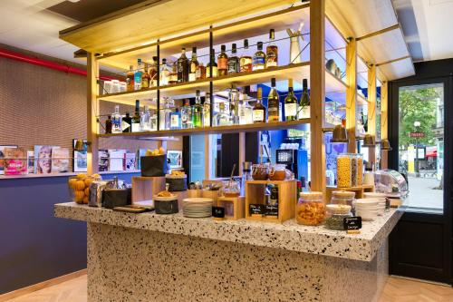 a bar with a lot of bottles on a counter at Oh la la ! Hotel Bar Paris Bastille in Paris