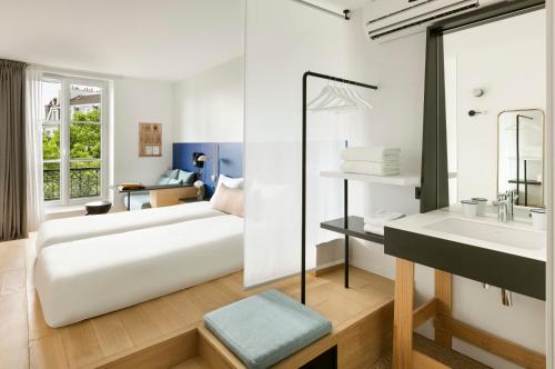 ein Hotelzimmer mit einem Bett und einem Waschbecken in der Unterkunft Oh la la ! Hotel Bar Paris Bastille in Paris