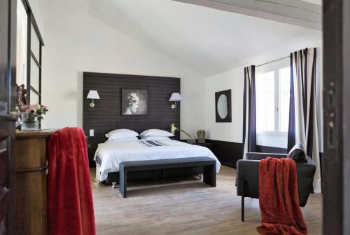 a bedroom with a bed and a chair in it at Les Jardins De La Livrée in Villeneuve-lès-Avignon