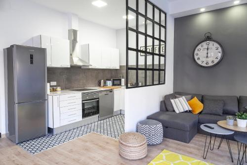 een keuken en een woonkamer met een bank en een klok bij Luxury Center Plaza Redonda in Valencia