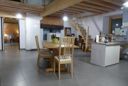 a kitchen and dining room with a wooden table and chairs at LES GALAINES in Abzac