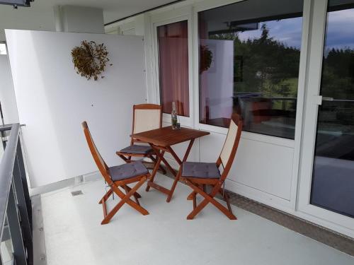 einen Tisch und Stühle auf einer Veranda mit einem Fenster in der Unterkunft Apartment Abendrot in Sankt Englmar