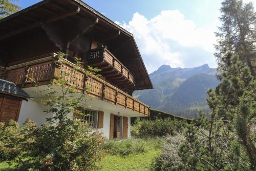 a building with a balcony and mountains in the background at Rose de Noël in Les Diablerets