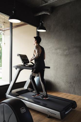 a man running on a treadmill in a gym at The Gallery Hotel Nai Harn in Nai Harn Beach