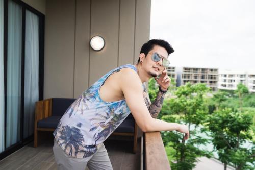 a man in sunglasses talking on a cell phone at The Gallery Hotel Nai Harn in Nai Harn Beach