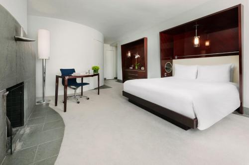a bedroom with a large white bed and a desk at Royalton New York in New York