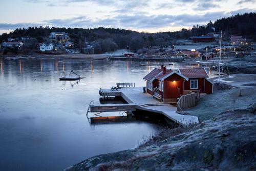 a small house on a dock on a body of water at Lagunen Cottages and Hostel in Strömstad