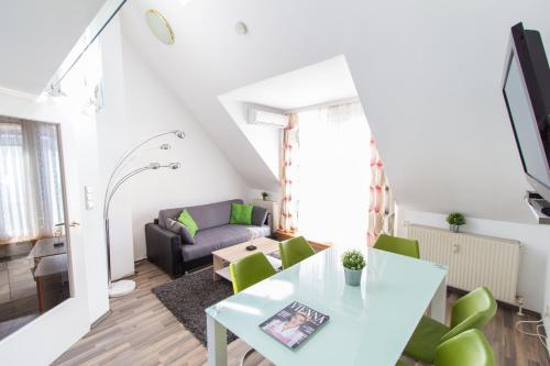 a living room with a table and green chairs at Karmeliter Flat | contactless check-in in Vienna
