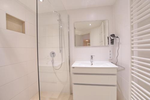 a white bathroom with a sink and a shower at Rettenberger Murmele in Rettenberg