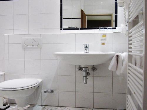 Motel Frankfurt في فرانكفورت ماين: حمام أبيض مع حوض ومرحاض