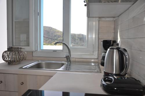 a kitchen counter with a sink and a window at Palaiokastro view in Karpathos Town