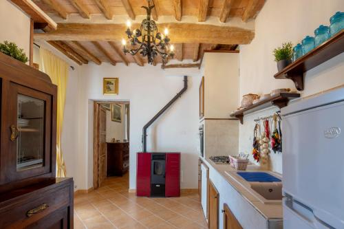 Cette chambre comprend une cuisine équipée d'un réfrigérateur rouge. dans l'établissement Appartamento stile toscano in Fauglia, à Fauglia