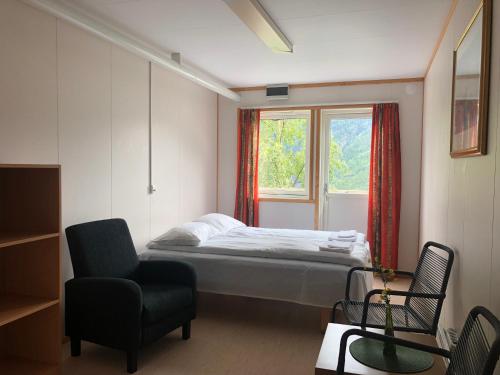 1 dormitorio con 1 cama, 1 silla y 1 ventana en Hellesylt Hostel and Motel, en Hellesylt
