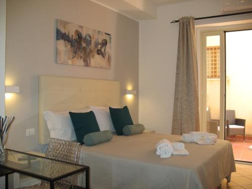 Un dormitorio con una cama con toallas. en Bed&Bed Tommaso Fazzello only rooms, en Taormina