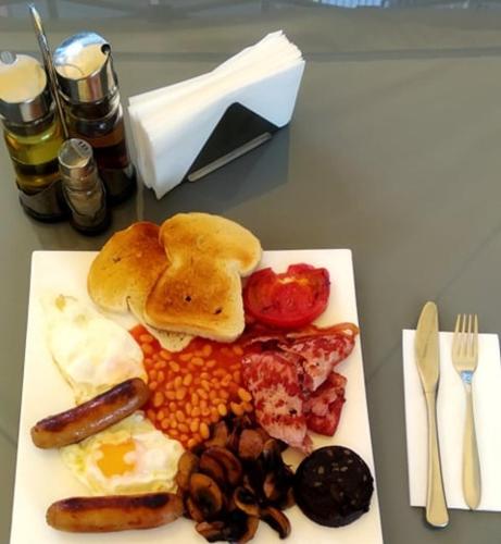een bord ontbijtproducten met eieren, bonen en spek bij Hotel Shipka Beach in Sunny Beach