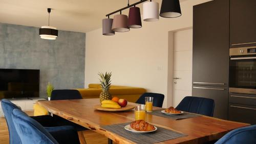 a dining room with a wooden table with fruit on it at Apartments Beautiful View in Omiš
