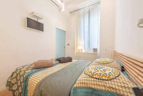 une chambre avec un lit avec une couverture dessus dans l'établissement Grimaldi, à Nice