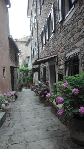 a stone alley with flowers in front of a building at Rooms Svalina in Grožnjan