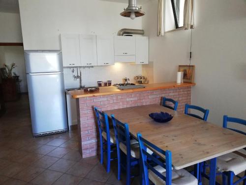 a kitchen with a wooden table and a refrigerator at Marinelli Guest House in Cisternino