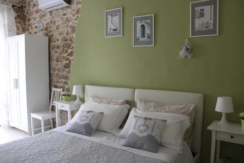 a green bedroom with a bed with white pillows at Il viandante in Sulmona