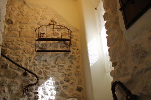 a room with a stone wall with a bird cage on the wall at Il viandante in Sulmona