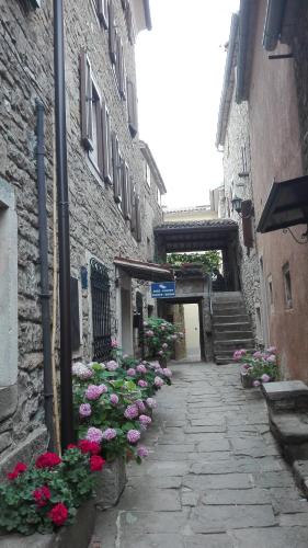 an alley with flowers on the side of a building at Rooms Svalina in Grožnjan