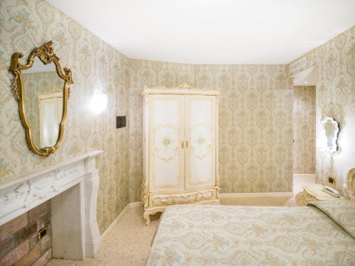 a bedroom with a bed and a dresser and a mirror at Dimora Marciana in Venice