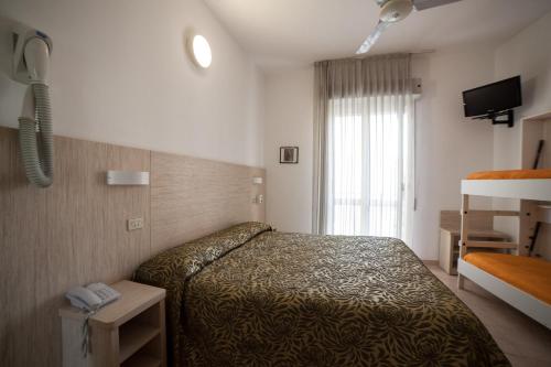 a hotel room with a bed and a window at Hotel Plaza in Rimini