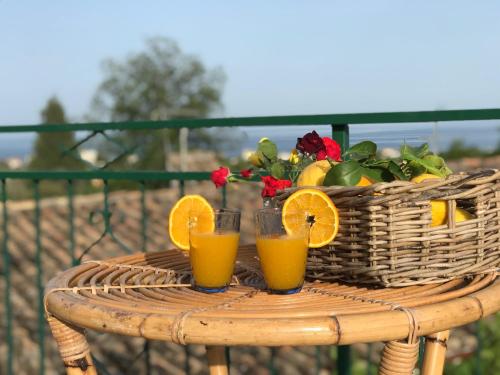 a basket of fruit and two glasses of orange juice at Arancetodamare_ZEUS in Trebisacce